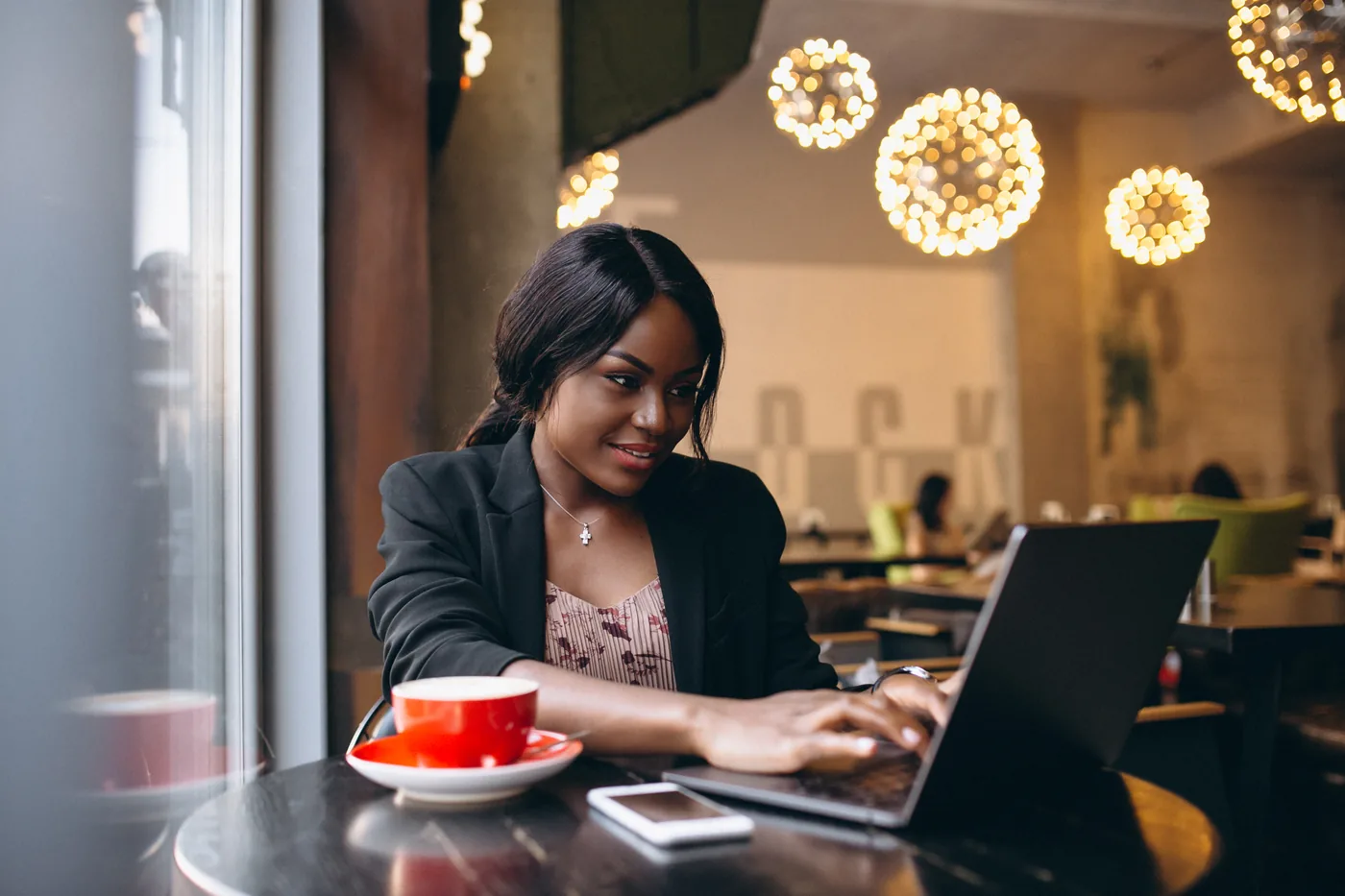 Woman working on a laptop in a cafe
